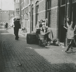 876894 Afbeelding van enkele vrouwen die op straat de was doen voor hun woningen in de Kroonstraat in Wijk C te ...